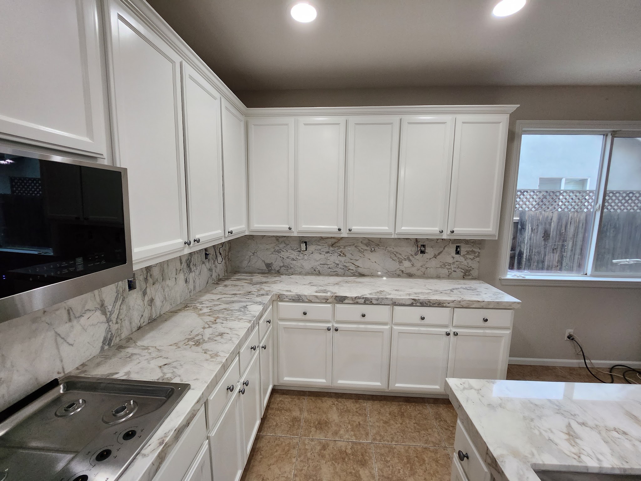 Refinished kitchen with new marble-look backsplash